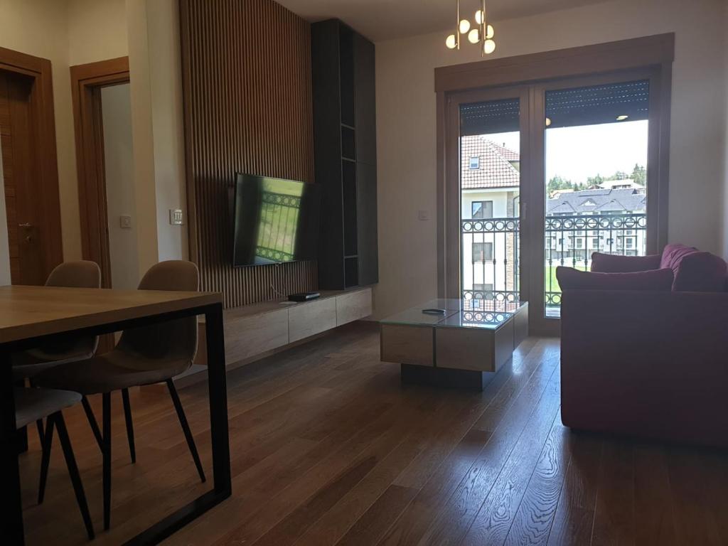 a living room with a dining table and a television at Vila Elsa in Zlatibor