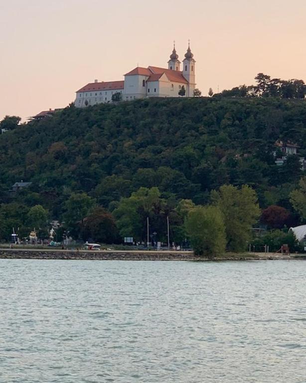 budynek na szczycie wzgórza obok wody w obiekcie Portum vendégház w Siófoku