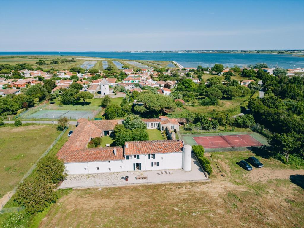 une vue aérienne sur un grand bâtiment blanc sur un champ dans l'établissement Domaine des Tours, à Loix