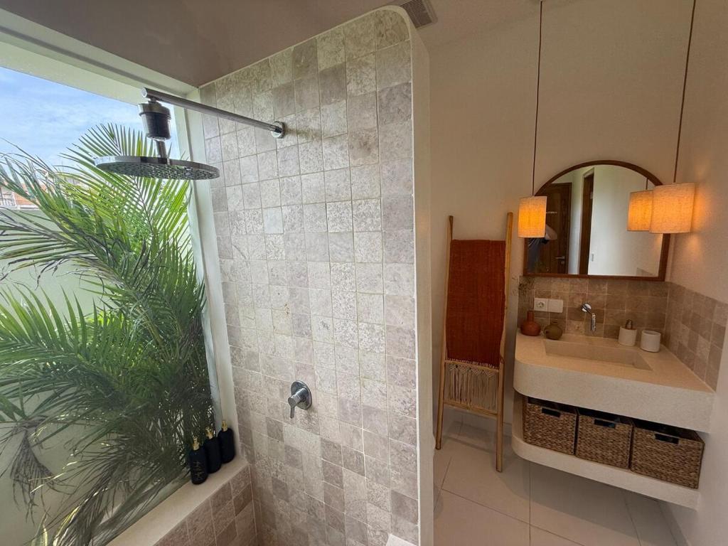 une salle de bain avec une douche avec un lavabo et un miroir dans l'établissement Amazing rice field-view Villa 3min walk to the sea, à Munggu