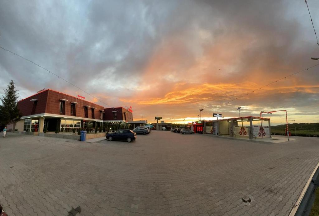 an empty parking lot with a sunset in the background at Hotel Veștem in Veştem