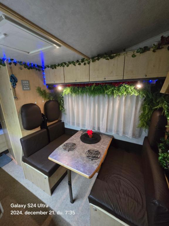 洛斯克里斯蒂亚诺斯Autocaravan,camper,campervan,motorhome,not driveable,only habitable的一辆带桌子的房车，还有一张沙发和一张桌子