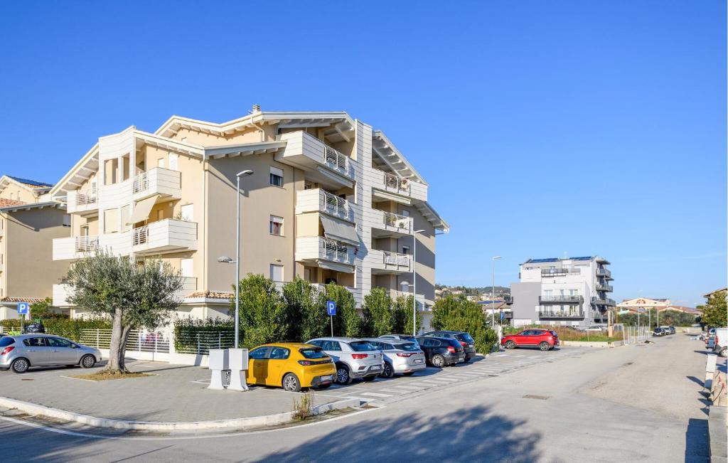 a parking lot with cars parked in front of a building at Cozy Apartment In Tortoreto Lido in Tortoreto Lido