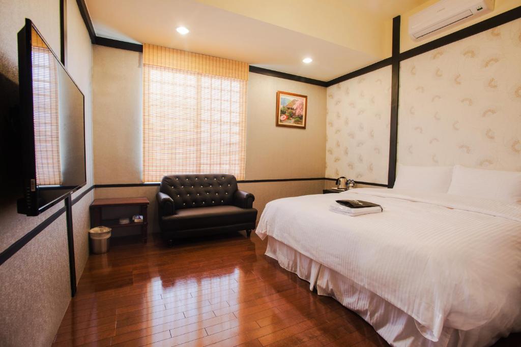 a hotel room with a bed and a chair at Hananoi Bed and Breakfast in Hengchun