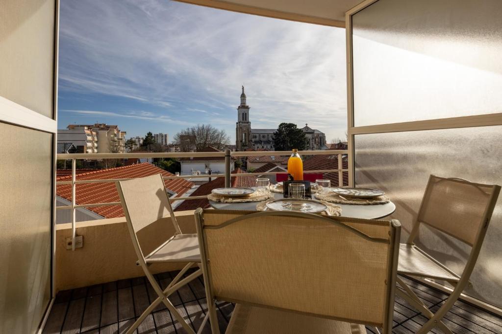 une table et des chaises sur un balcon avec vue dans l'établissement Bassin Bleu - Vue sur le port d'Arcachon, à Arcachon
