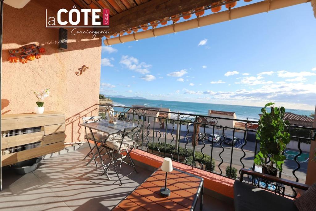 a balcony with a table and a view of the ocean at L'Espéron in Sausset-les-Pins