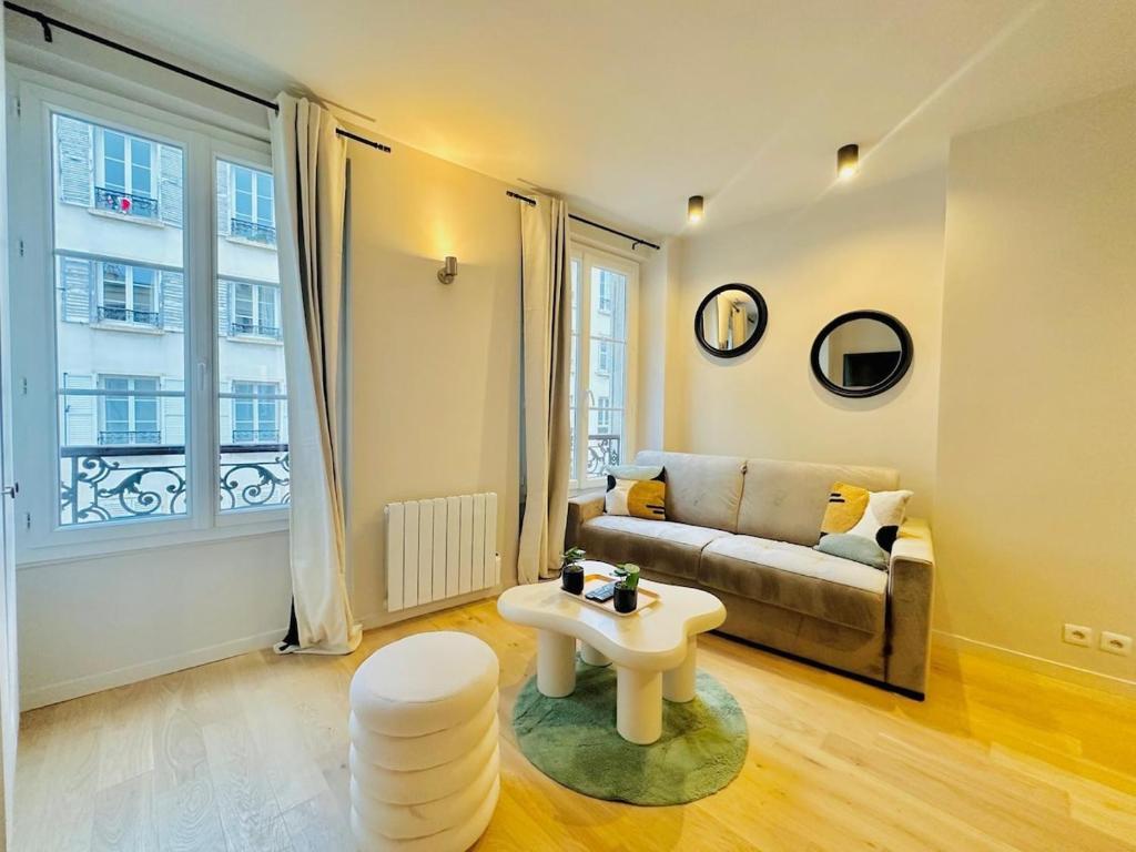 un salon avec un canapé et une table dans l'établissement L'Eiffel - Charmant studio proche Tour Eiffel, à Paris
