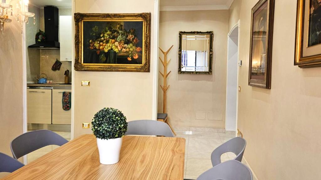 una sala da pranzo con tavolo e un dipinto di fiori di Rome Boulevard Suite a Roma