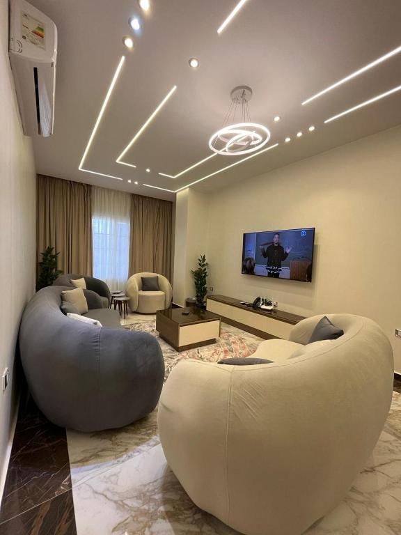 a living room with a large couch and a tv at Zayed Plaza-زايد بلازا in Cairo