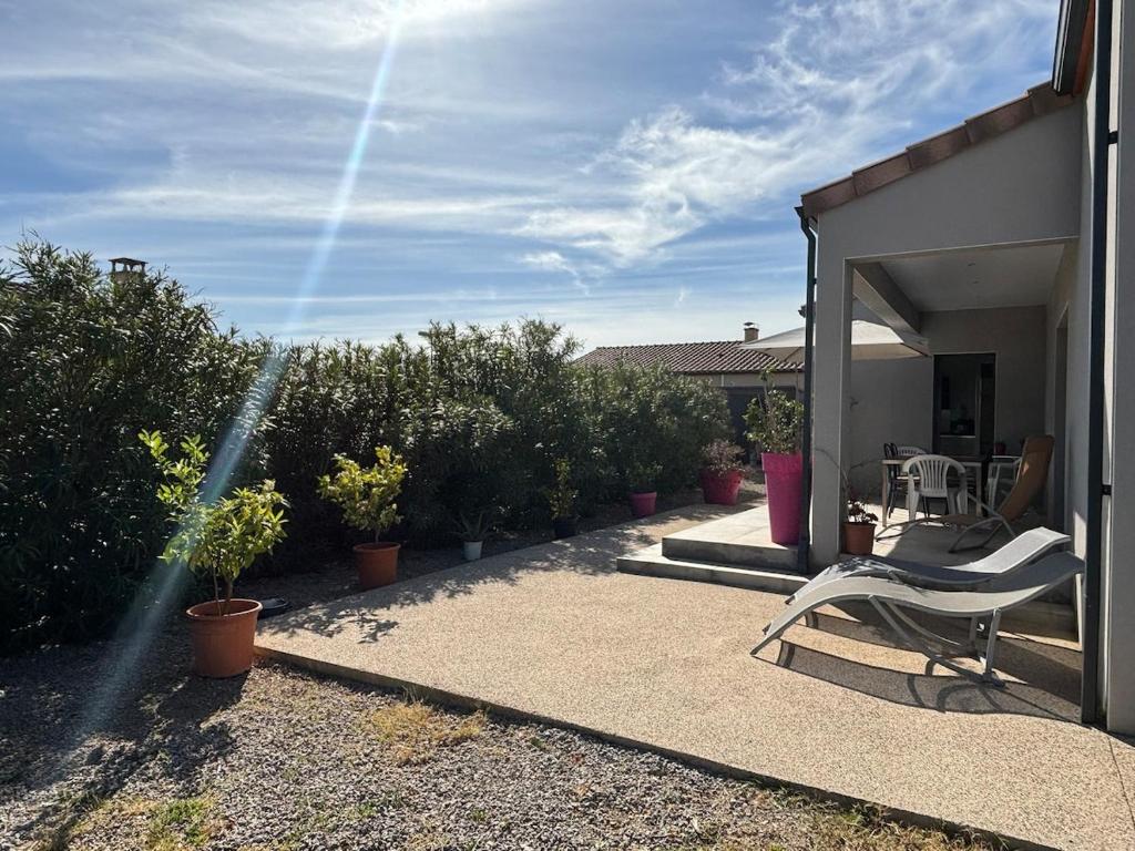 un patio avec une chaise et des plantes dans l'établissement La Maison Laurier, à Lézignan-Corbières