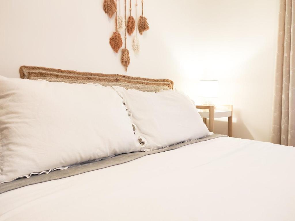 un letto con lenzuola bianche e cuscini sopra di Apartamento - Casa Churruca - Zamora a Zamora