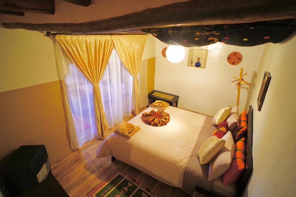 a bedroom with a bed and a window at Kasbah El Hajja in Aït Benhaddou