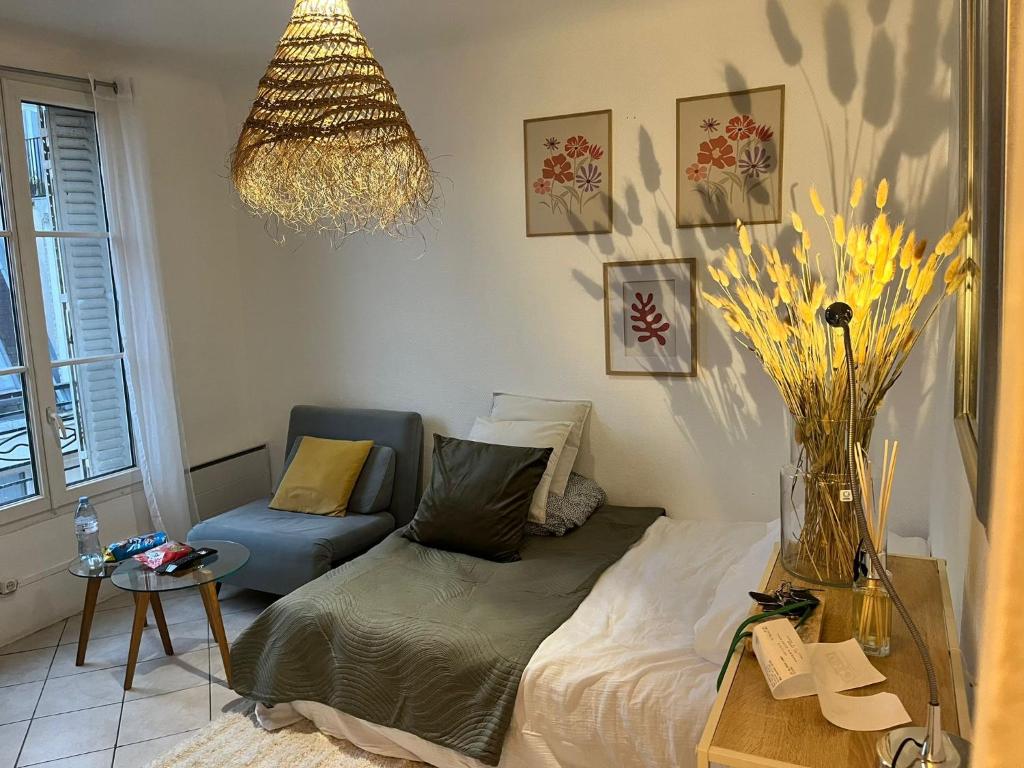 - un salon avec un lit et un vase de fleurs dans l'établissement Élégant cocon lumineux au cœur de Paris, à Paris
