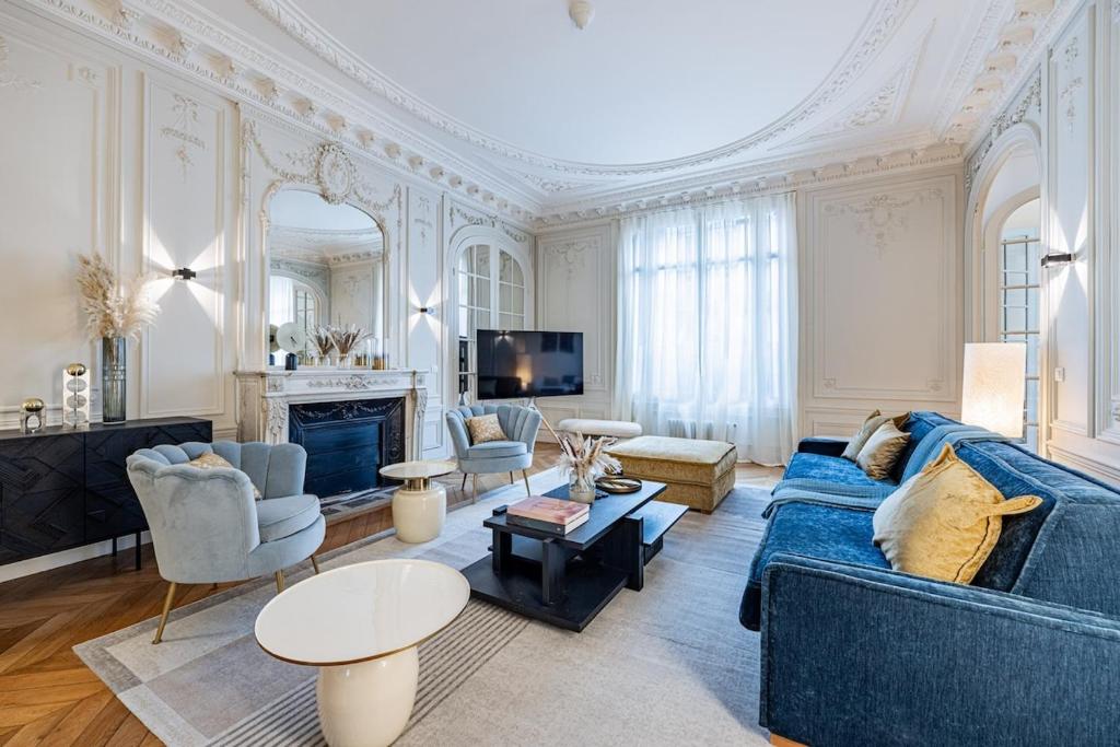 un salon avec un canapé bleu et une cheminée dans l'établissement Amazing Apartment 4Bedrooms Champs Elysées AC, à Paris