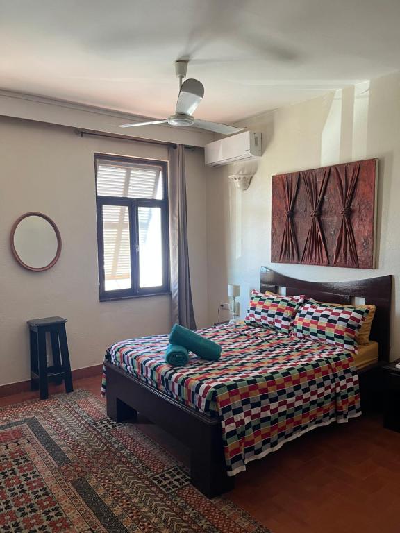 a bedroom with a bed and a ceiling fan at Maison d Afrique - Séjour convivial à Saly, proche plage et activités in Saly Portudal