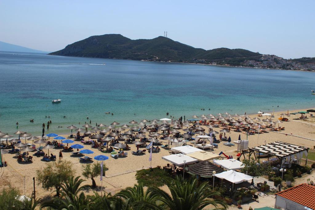 plaża z parasolami i ludzie na plaży w obiekcie Vournelis Beach Hotel and Spa w mieście Iraklitsa