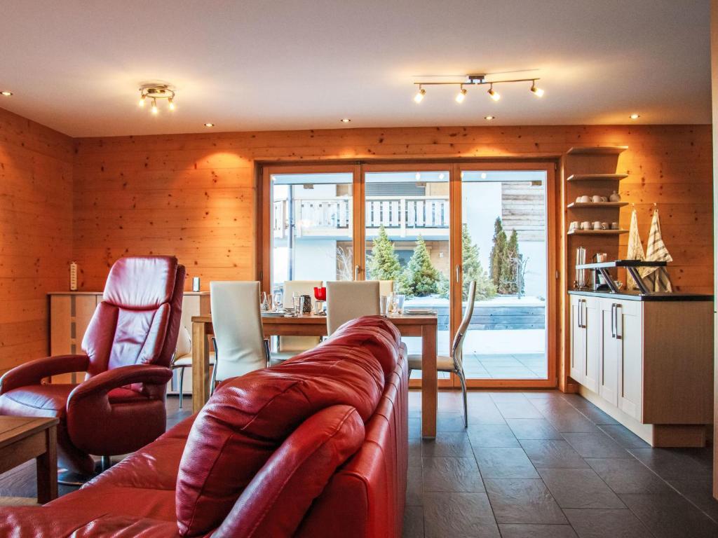 a living room with a leather couch and a table at Apartment Moulin du Raé A2 by Interhome in Nendaz