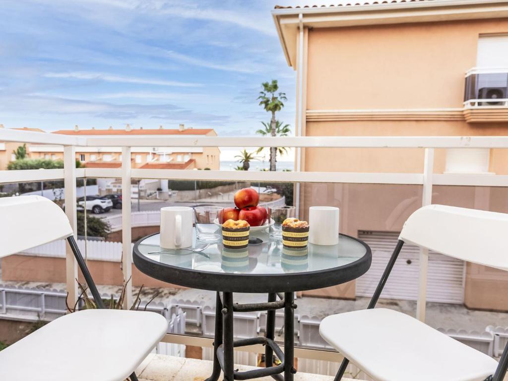 a table with fruit on a balcony with chairs at Holiday Home Llevant by Interhome in Creixell