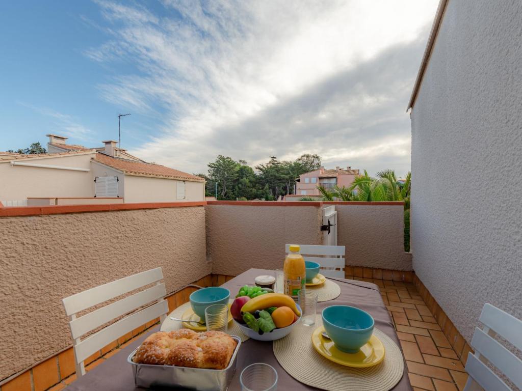 une table avec un bol de fruits sur un balcon dans l'établissement Apartment Les Casellas by Interhome, à Saint-Cyprien