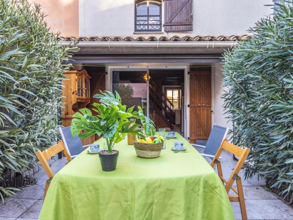 un tavolo con una tovaglia verde su un patio di Apartment Cap Caddy by Interhome ad Agde