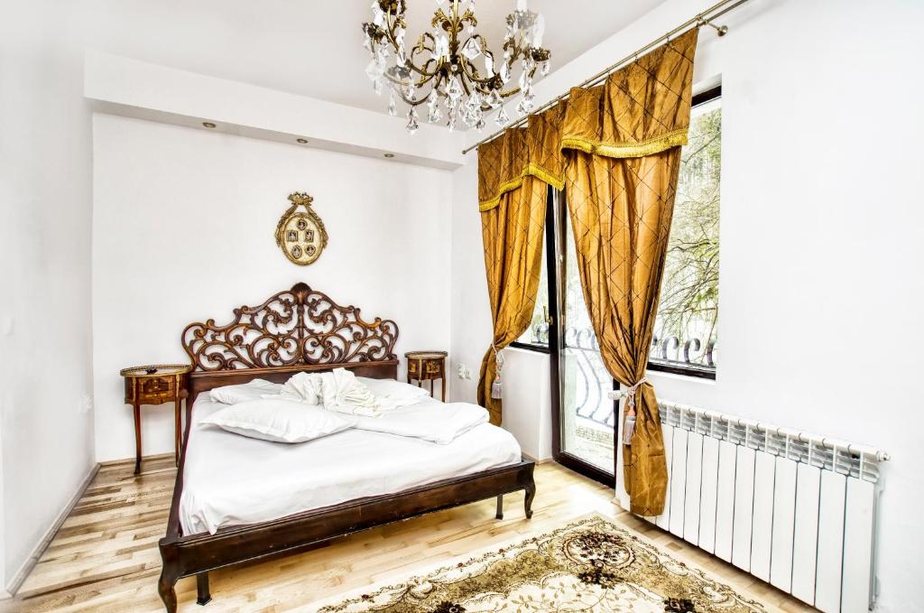 a bedroom with a bed and a chandelier at Hotel Coroana Moldovei in Slănic-Moldova