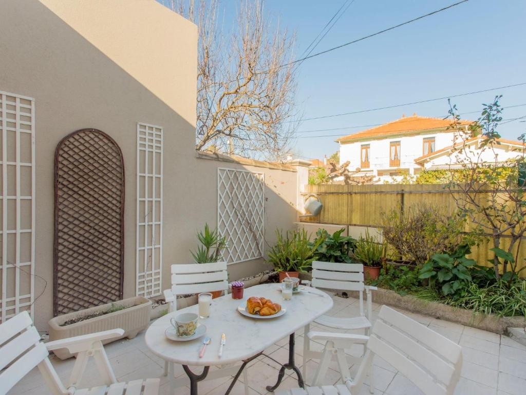 un patio avec une table et des chaises et une clôture dans l'établissement Apartment Phichris by Interhome, à Hyères