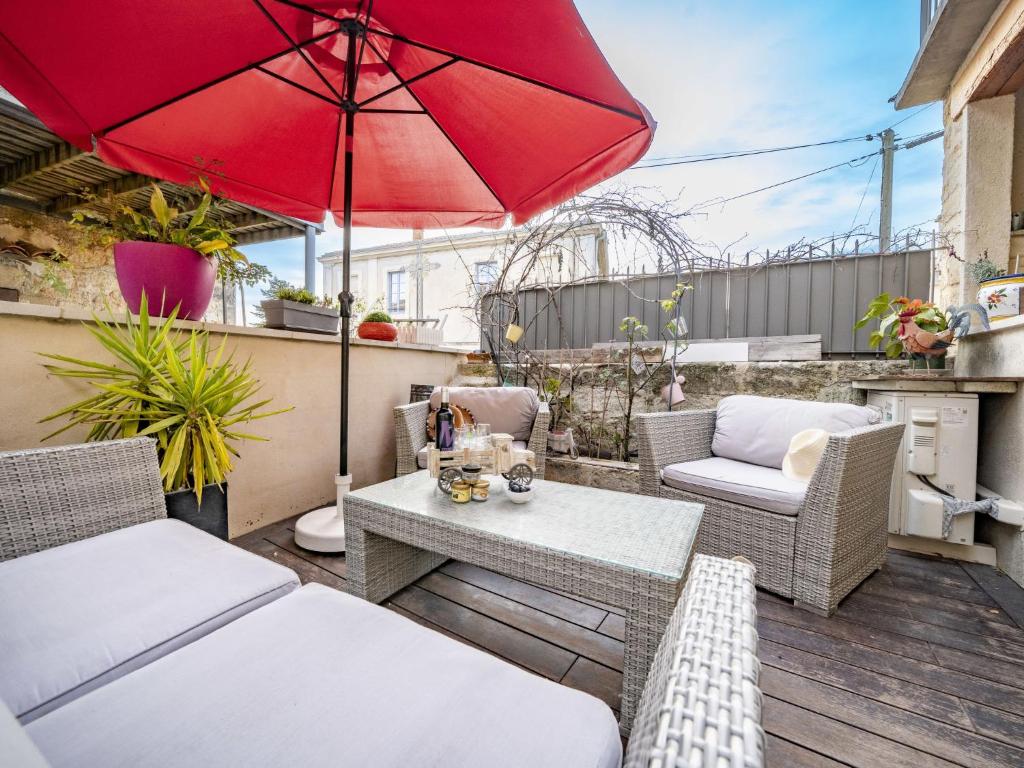d'une terrasse avec une table et un parasol rouge. dans l'établissement Holiday Home Maison de Castries by Interhome, à Castries