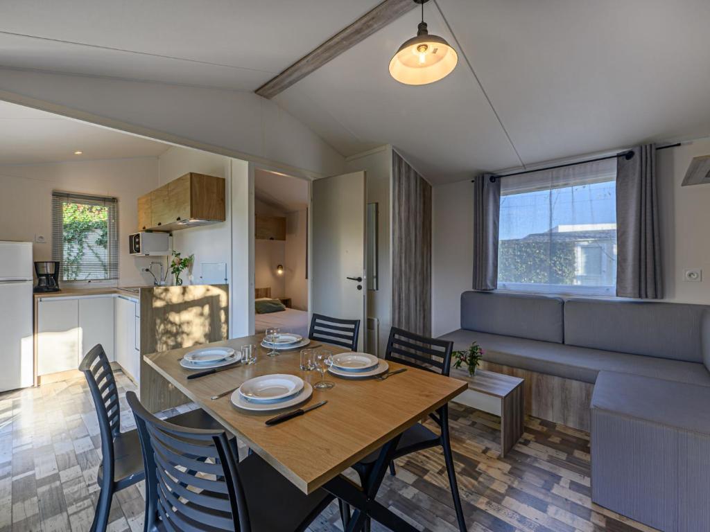カルナックにあるApartment Le Cygne by Interhomeのテーブルと椅子のあるダイニングルームとリビングルーム
