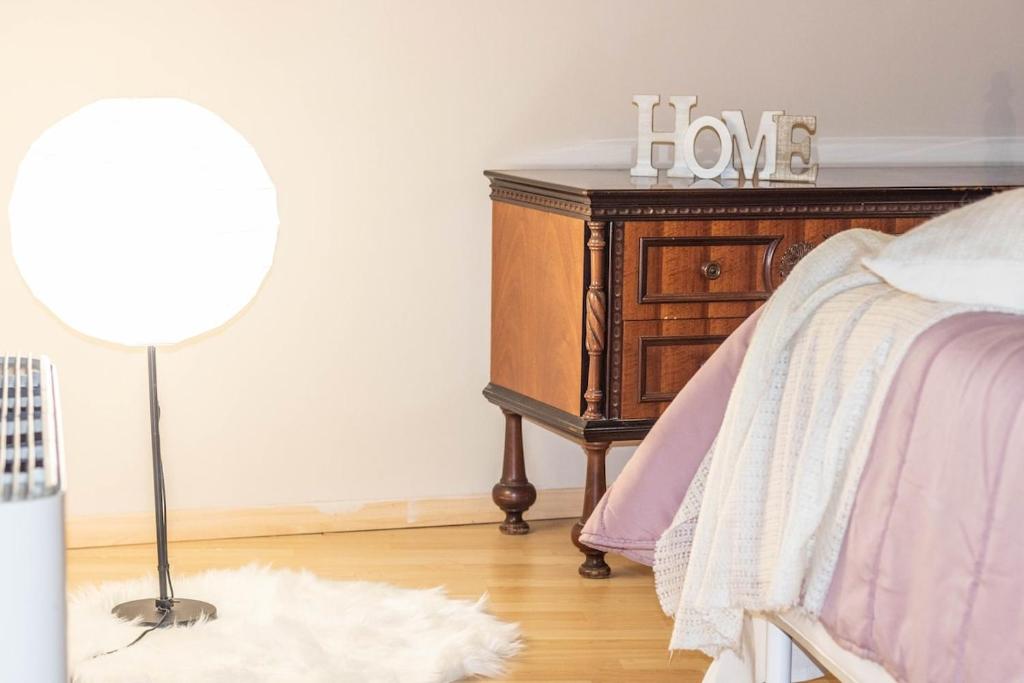 a bedroom with a bed with a wooden dresser and a lamp at Attico Elegante Centralissimo in Chiaravalle