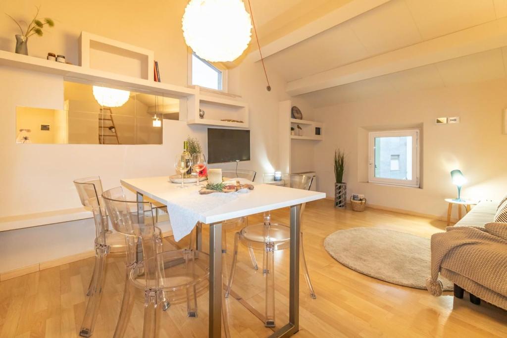 a kitchen and living room with a table and chairs at Attico Elegante Centralissimo in Chiaravalle