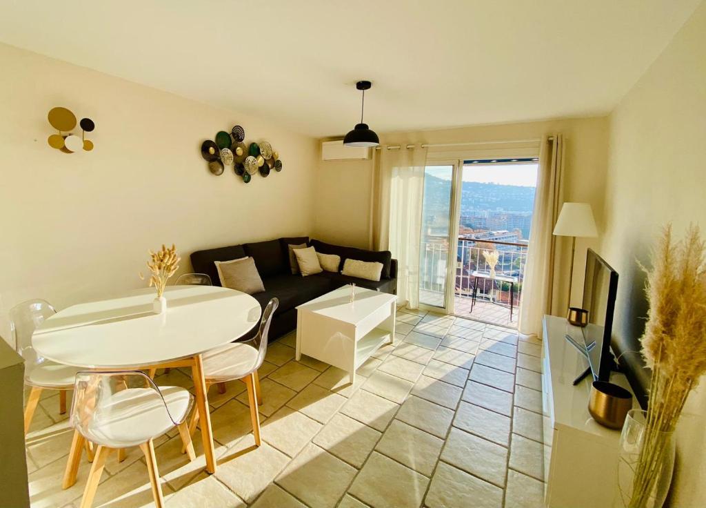 un salon avec une table et un canapé dans l'établissement Appartement 4 pièces avec vue mer et stationnement privé à Nice, à Nice