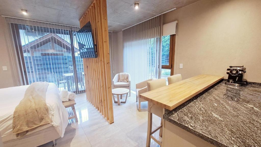 ein Zimmer mit einem Bett und einem Tisch und Stühlen in der Unterkunft Blizu II in Villa La Angostura