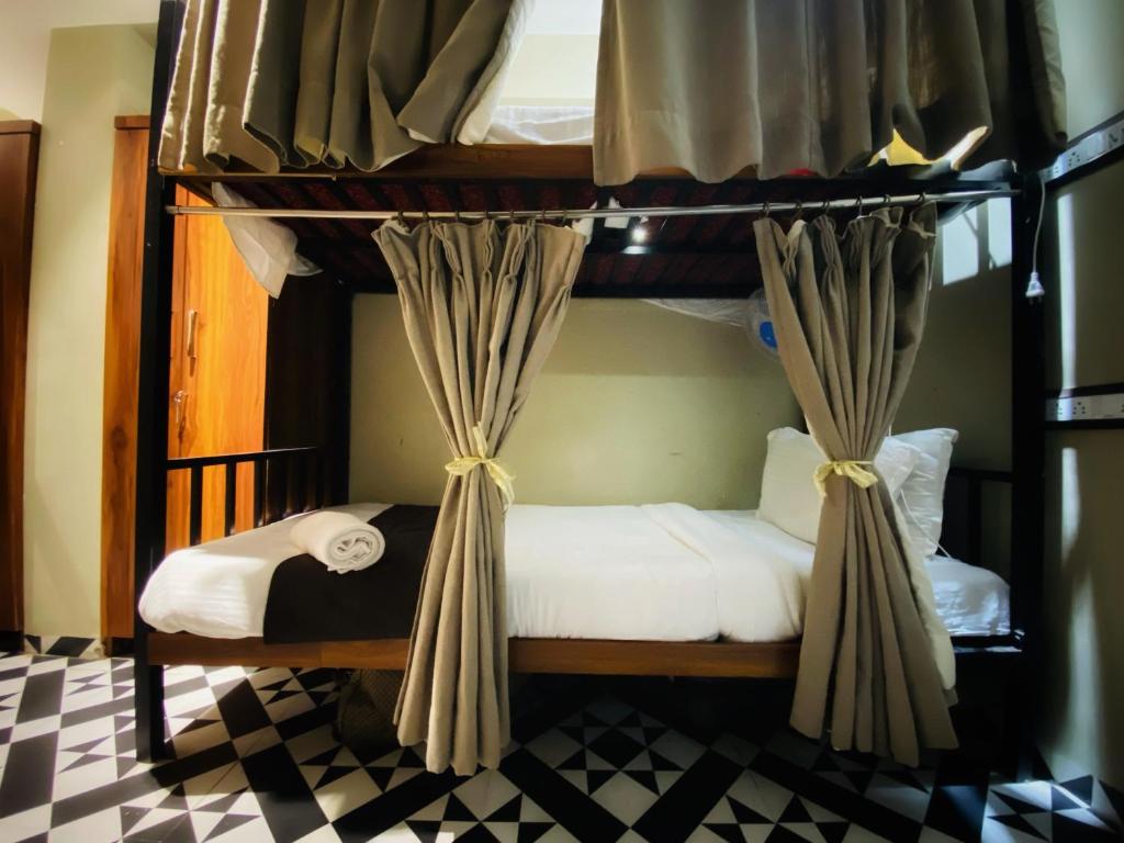 a bedroom with two bunk beds with curtains at Sulu Stay Inn Near Mumbai International Airport in Mumbai