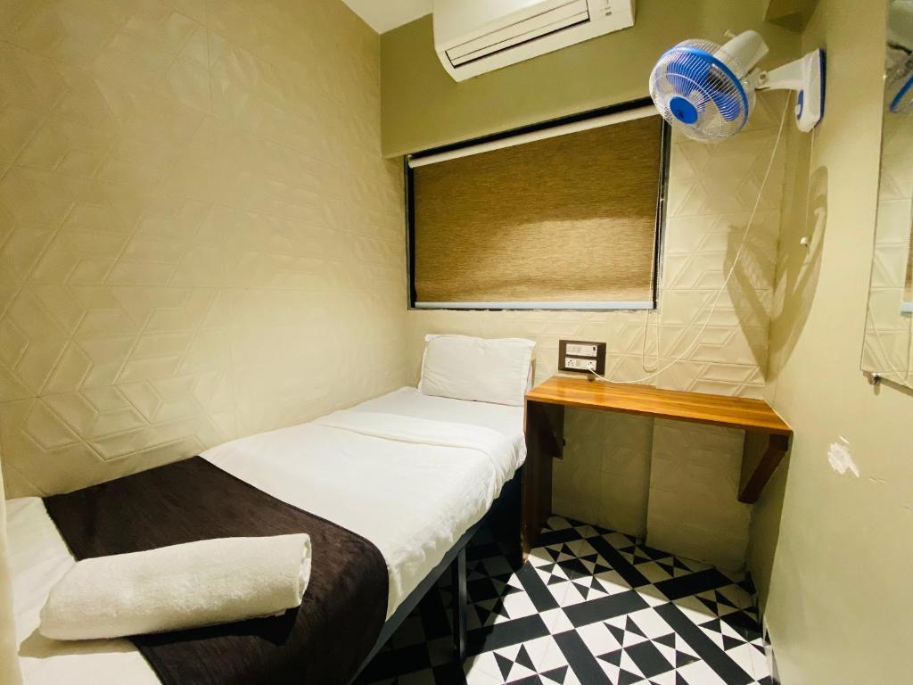 a small room with a small bed and a window at Sulu Stay Inn Near Mumbai International Airport in Mumbai