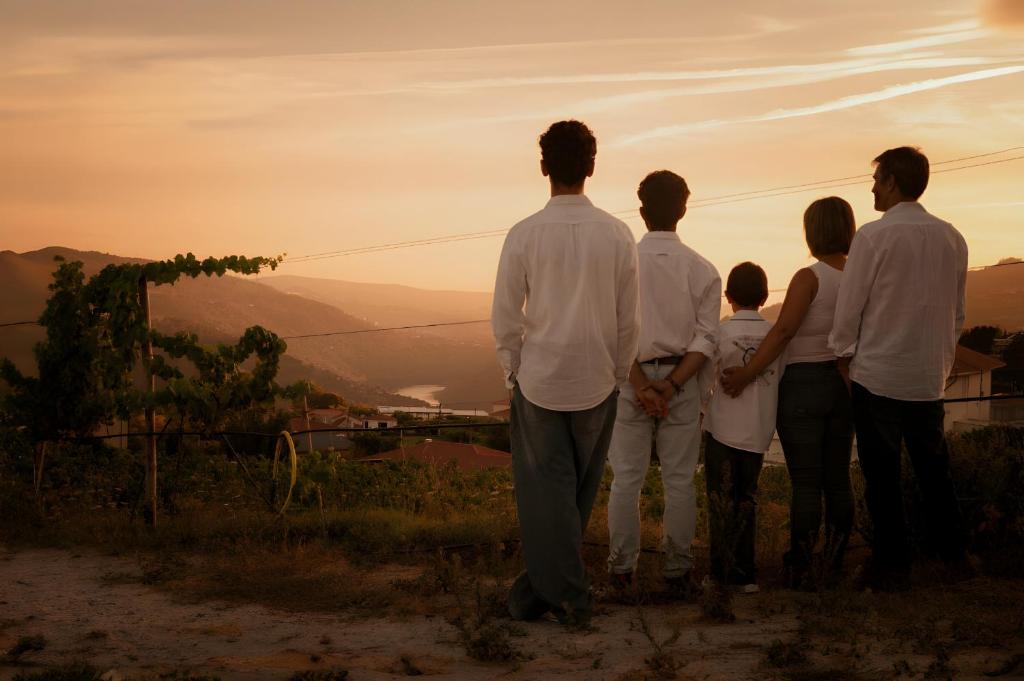 a family standing on a hill watching the sunset at Canhoto Douro in São Lourenço do Douro