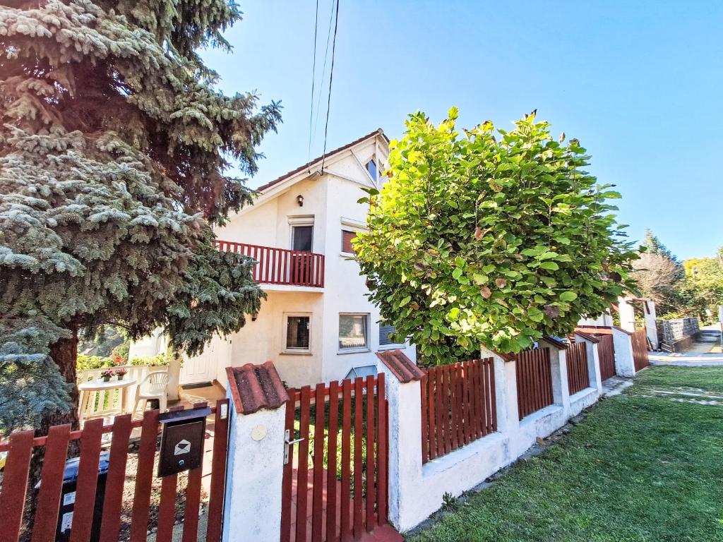 a fence in front of a house with trees at Apartment Bonika by Interhome in Fonyód