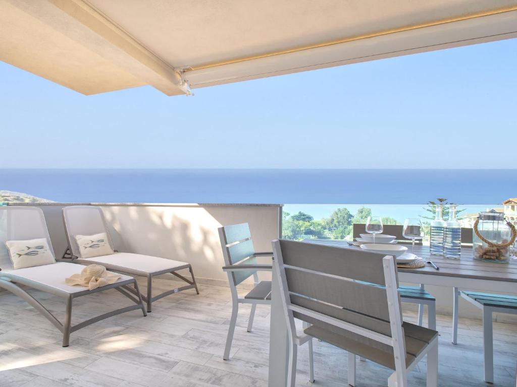 a patio with chairs and a table and a bench at Apartment Mare Azzurro by Interhome in La Ciaccia