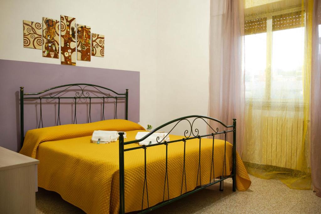 - une chambre avec 2 lits avec des draps jaunes et une fenêtre dans l'établissement La casa di Francesca, à Matera