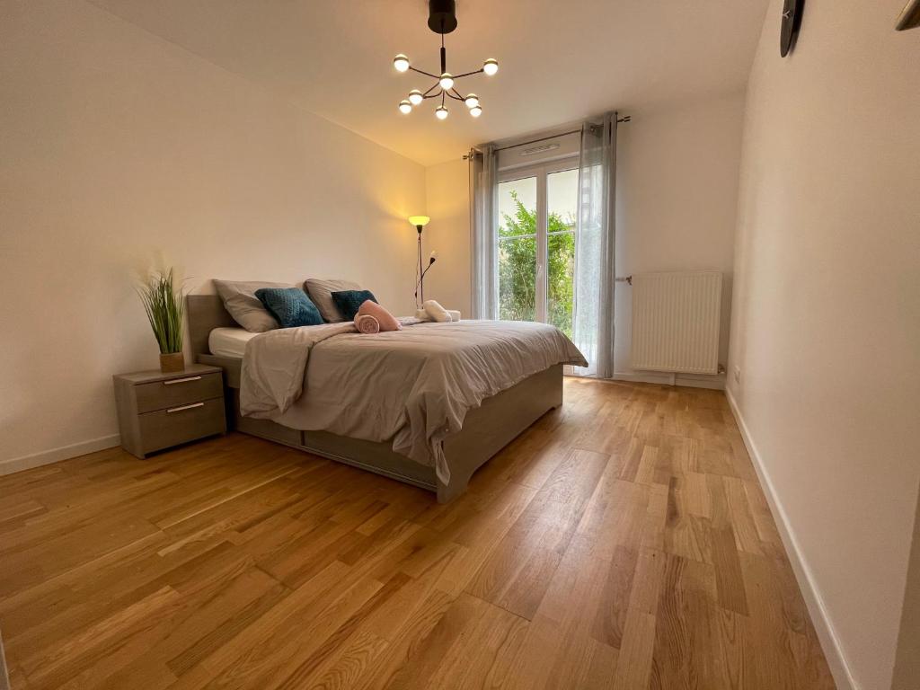 une chambre avec un lit et une fenêtre dans l'établissement Appart Delphine Montevrain, à Montévrain