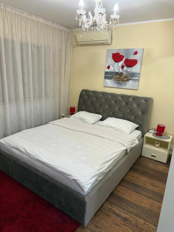 a bedroom with a bed with white sheets and a chandelier at Ambiance studio in Galaţi