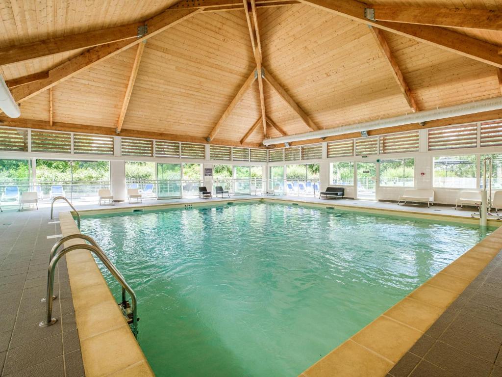 une grande piscine intérieure avec un plafond en bois dans l'établissement Holiday Home Cottage Privilège - SUM103 by Interhome, à Saumur