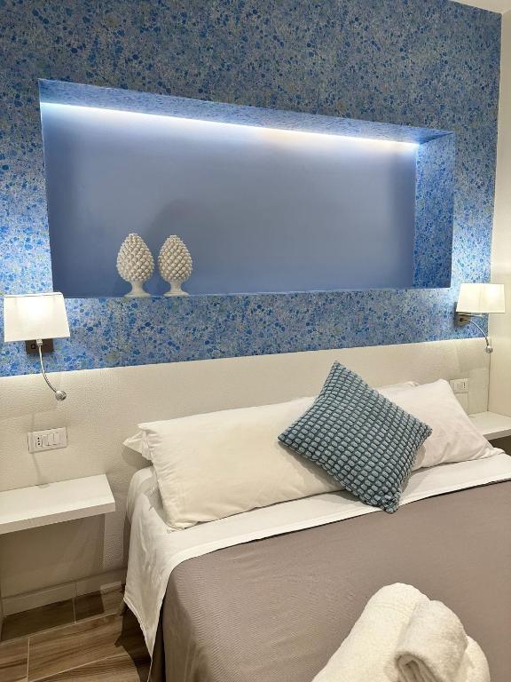 a room with a bed with a blue wall at Ines Apartments in Giardini Naxos