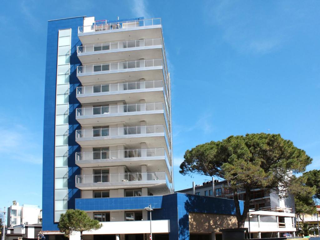 a tall building with a tree in front of it at Apartment Nashira-5 by Interhome in Lignano Sabbiadoro