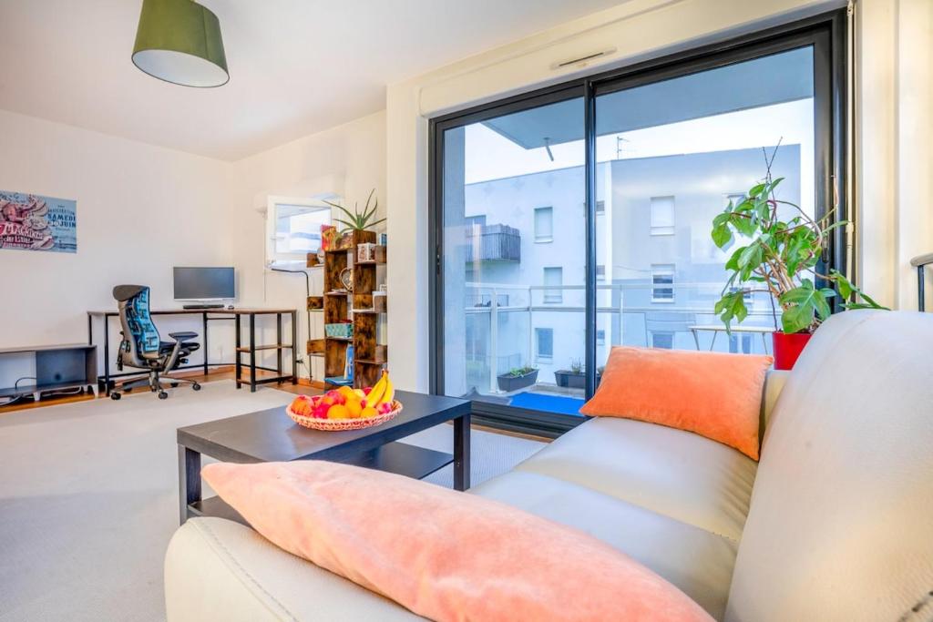 un salon avec un canapé et une table dans l'établissement Mail Pablo Picasso BIS -Parking, à Nantes