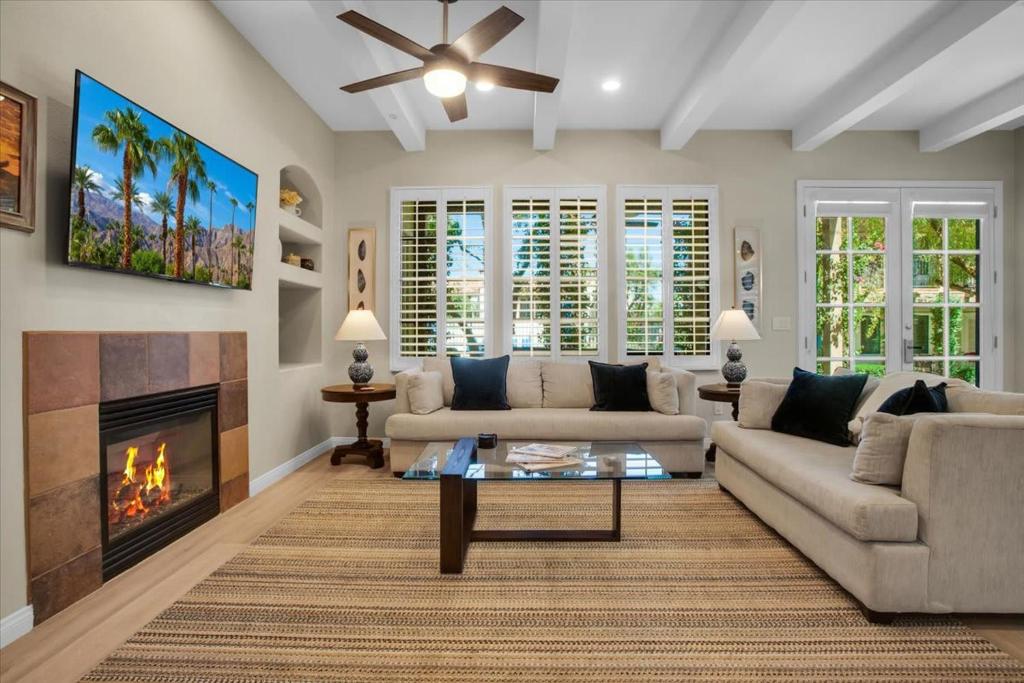 a living room with a couch and a fireplace at Modern LQ 3BR Getaway Steps to pool & spa in La Quinta
