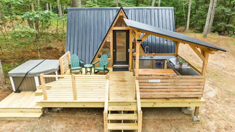 a tiny house with a deck and a grill at A Serene A-Frame Cabin with Hot Tub in Oxford