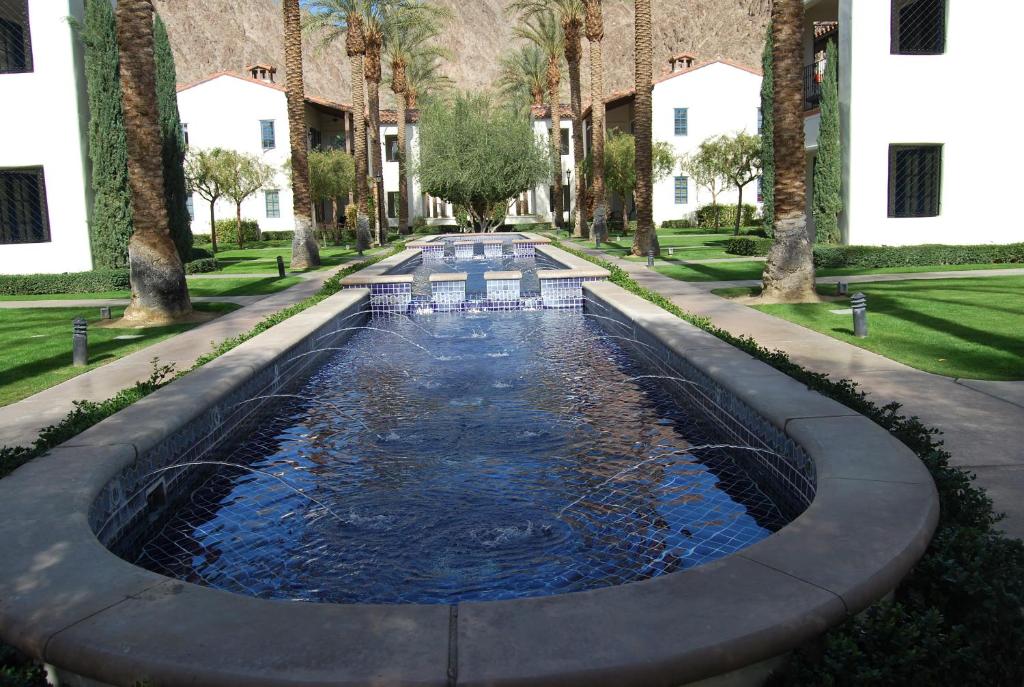 una piscina en medio de un patio con palmeras en Gorgeous Ground Floor Villa Near Main Pool, en La Quinta