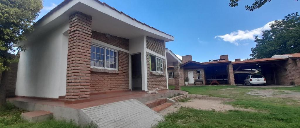 a home with a brick house with a driveway at Cabañas La Cumbre Palermo in La Cumbre