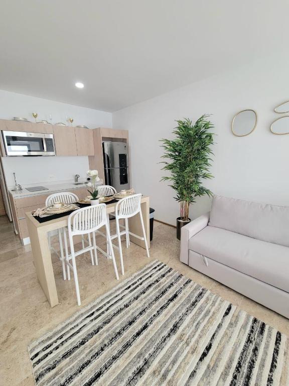 a living room with a couch and a table and chairs at Condo en el corazon de Playa del Carmen in Playa del Carmen