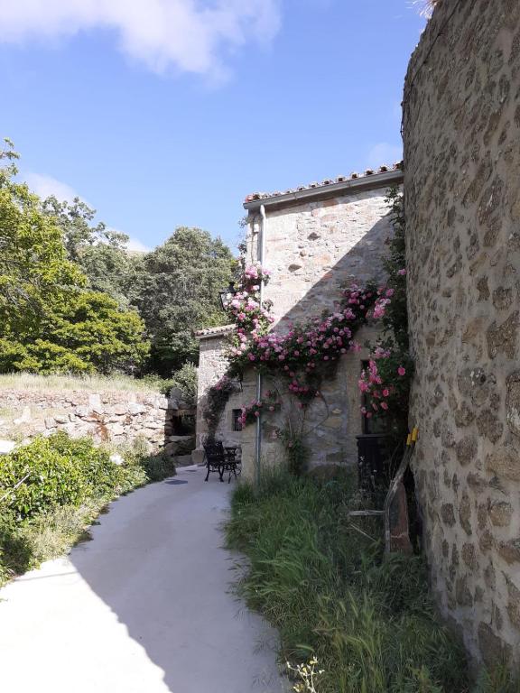a stone building with flowers on the side of it at El Embalse in Los Loros
